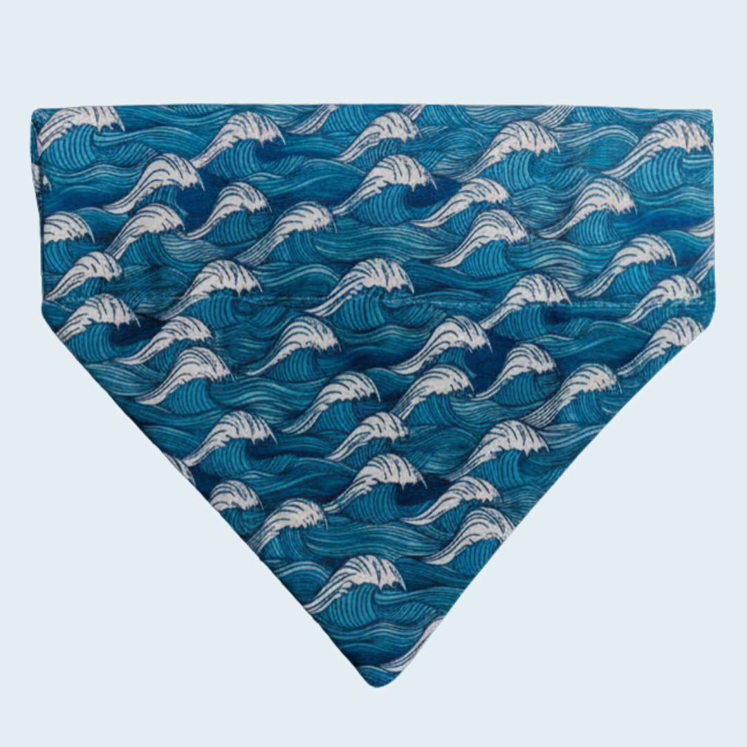 Catching Waves dog bandana with white waves on blue, shown flat