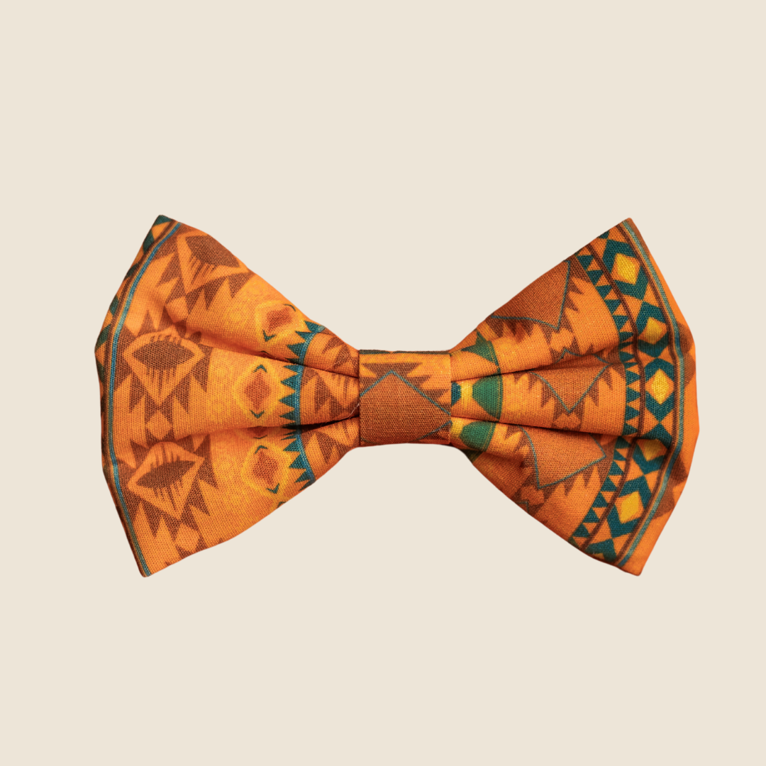 Mountain Aztec dog bow tie with orange and teal geometric print, front view