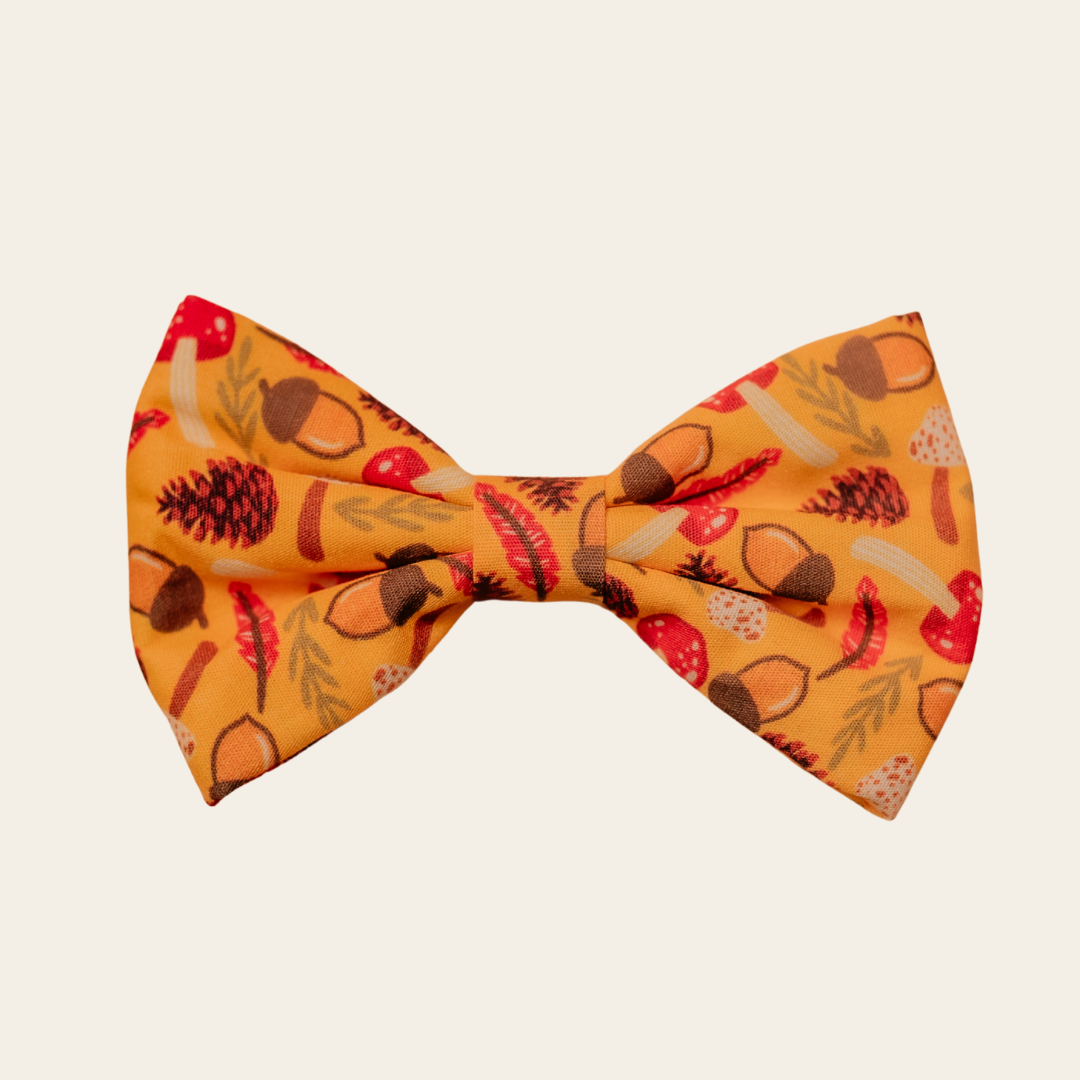 Woodland Treasure dog bow tie with red and brown woodland motifs on mustard, front view