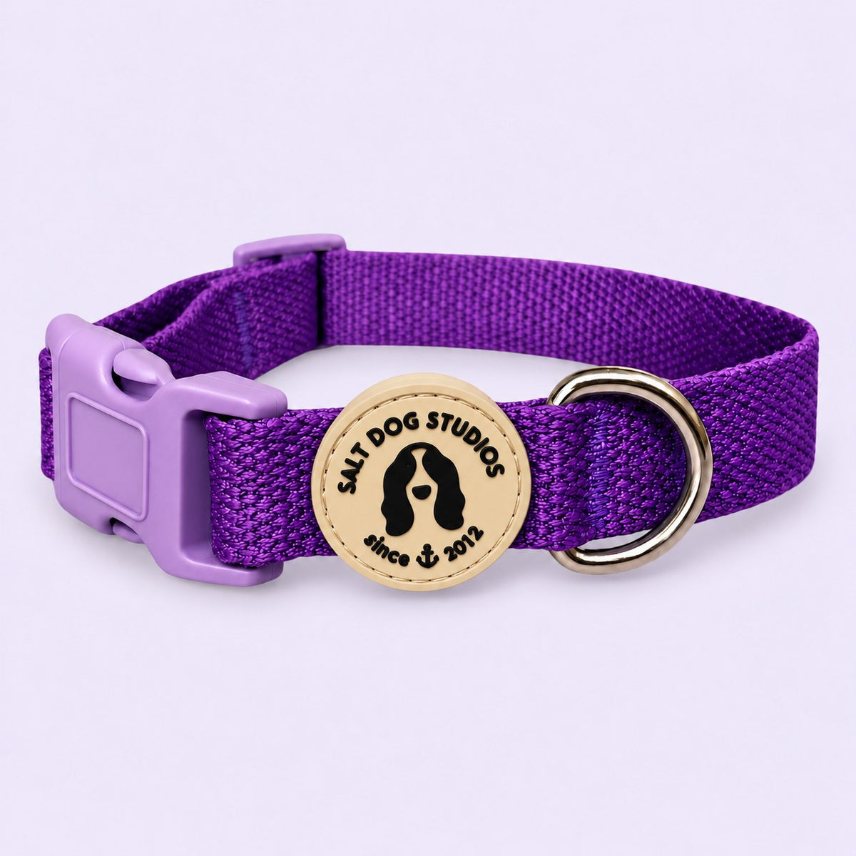 Salt Dog Studios plain indigo purple hemp dog collar, matching buckle and metal D-ring on a pale lavender background.
