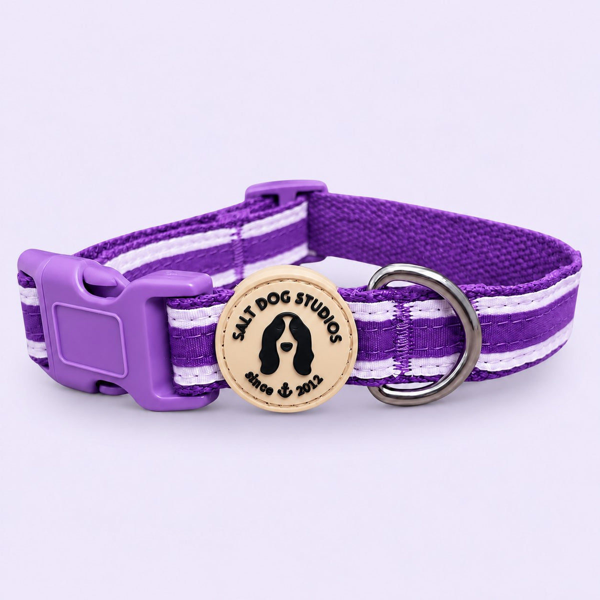 Salt Dog Studios striped indigo purple hemp dog collar with white ribbon stripes, matching purple buckle and metal D-ring on a pale lavender background.