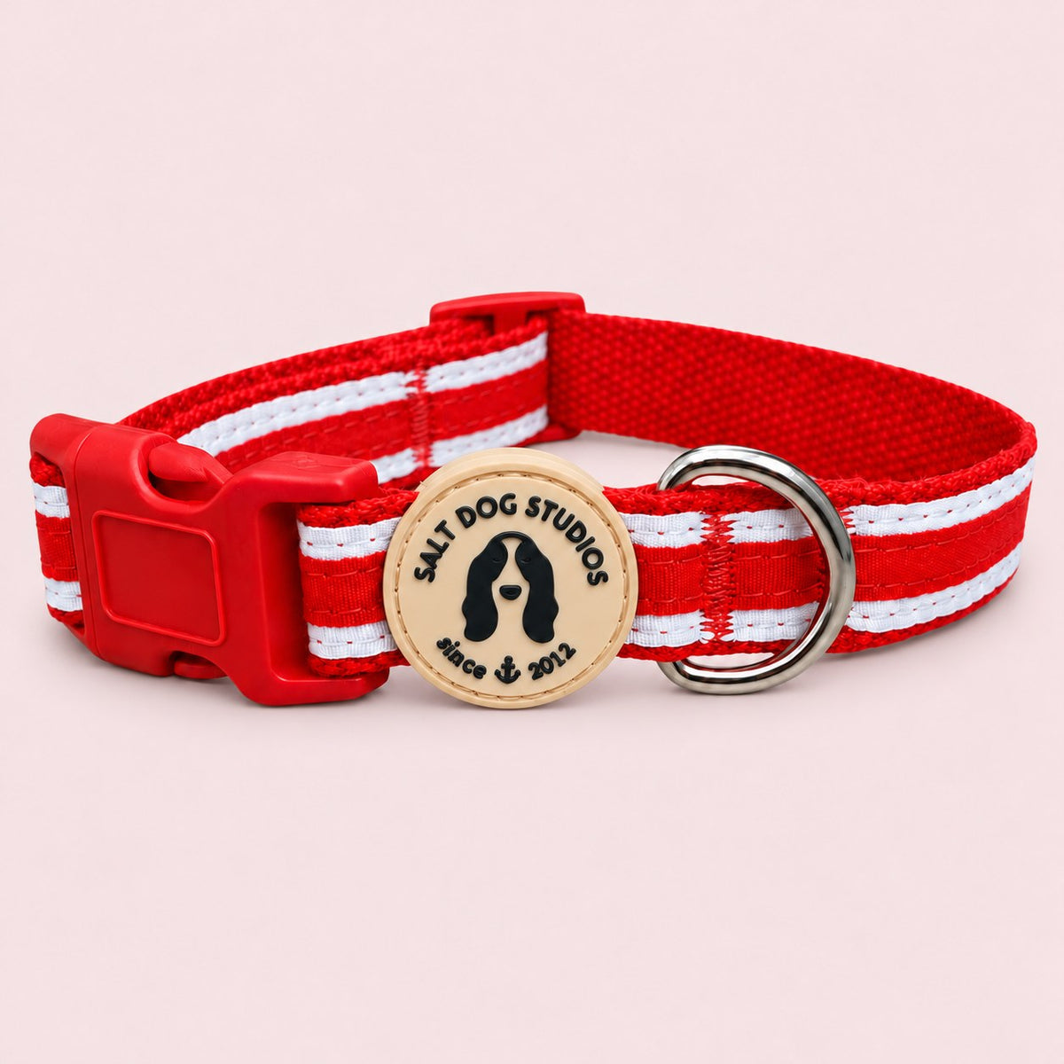 Salt Dog Studios striped scarlet red hemp dog collar with white ribbon stripes, matching buckle and metal D-ring on a rose blush background.