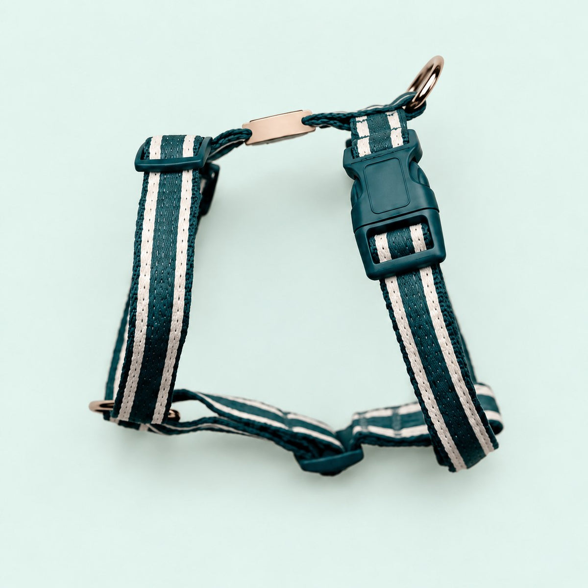 Salt Dog Studios striped dark teal hemp dog harness with adjustable straps and matching buckle, with white ribbon stripes on a pale mint green background.